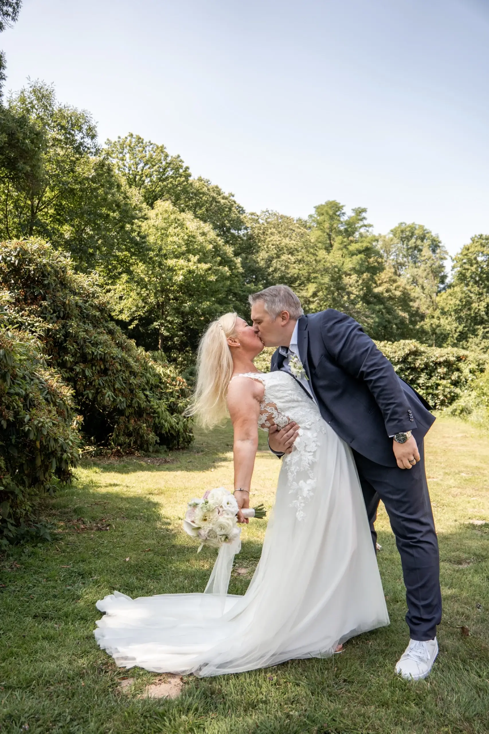Hochzeitspaar küsst sich im Garten